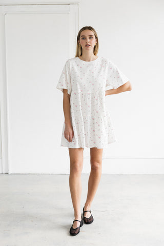 Woman wearing a white lace dress against a plain background