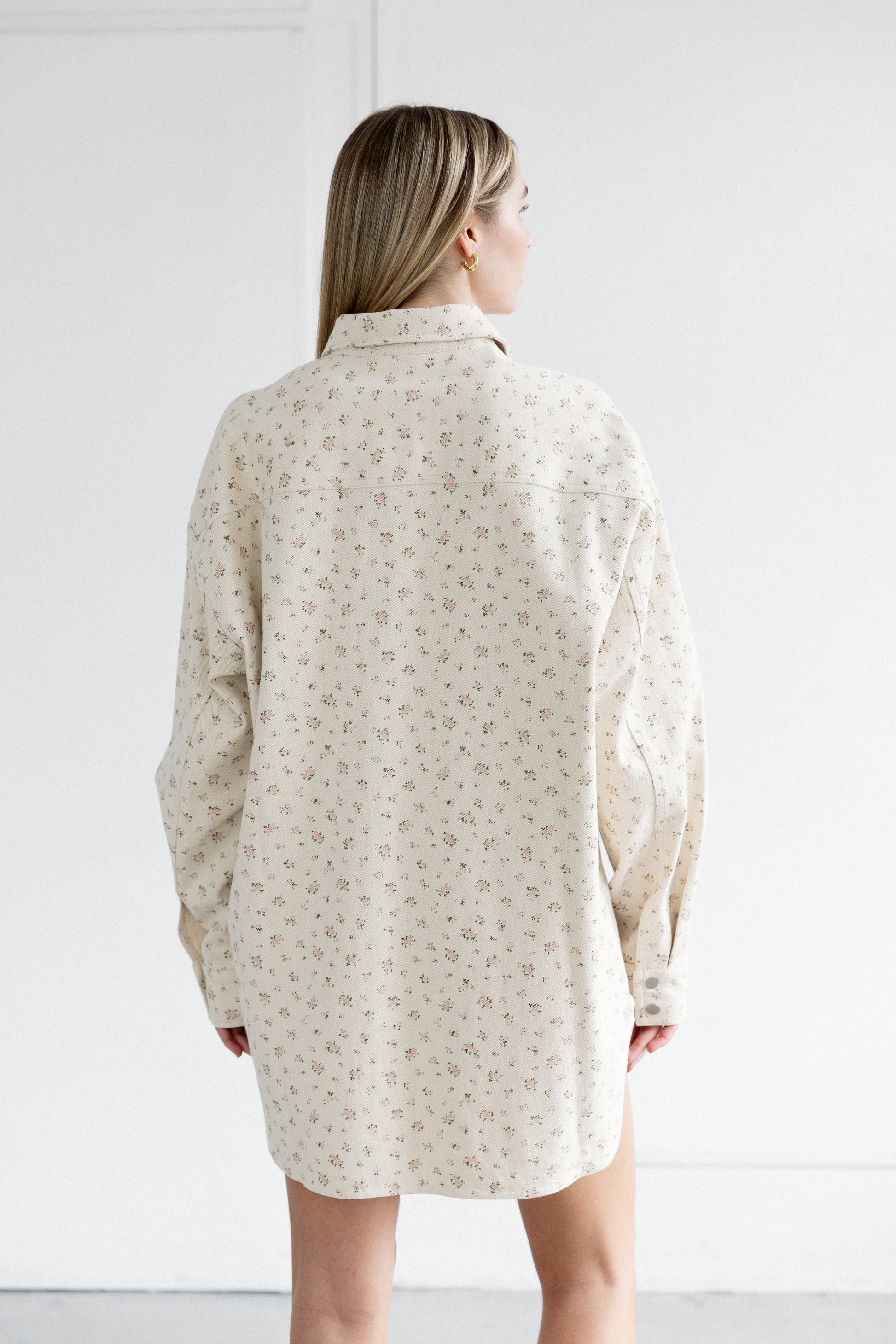 Woman wearing a beige patterned dress against a white background