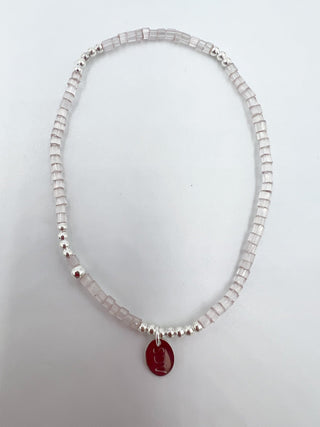 Necklace with a red pendant on a light gray background
