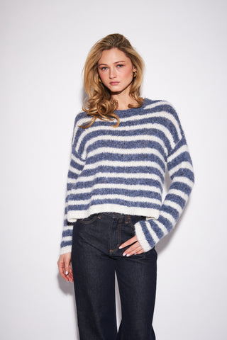 Woman wearing a blue and white striped sweater on a white background