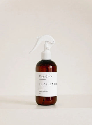 Brown spray bottle with a white label on a light beige background