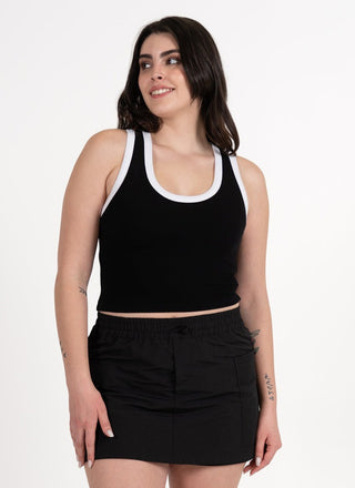 Woman wearing a black tank top and skirt on a white background