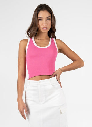 Woman wearing a pink  tank top and skirt on a white background