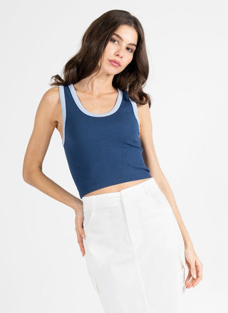 Woman wearing a blue tank top and skirt on a white background
