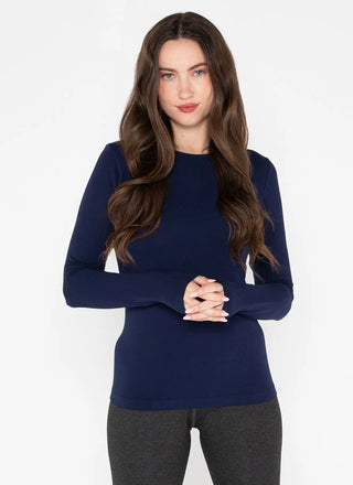 Woman wearing a navy blue long-sleeve top against a white background