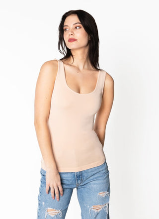 A woman wearing a bamboo tank top with short length, paired with jeans.