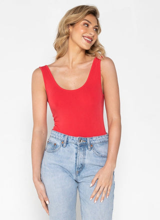 A woman wearing a bamboo tank top with short length, paired with jeans.
