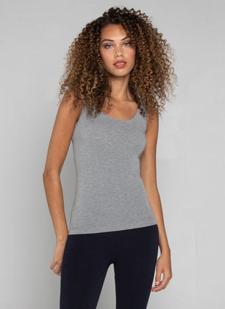 A woman wearing a bamboo tank top with short length, paired with leggings.