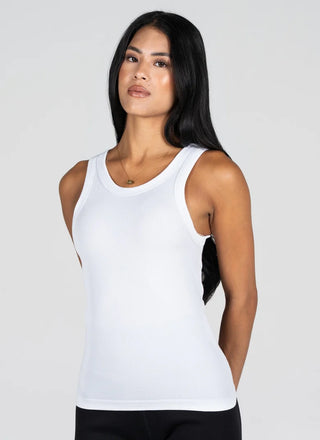 A woman modeling a white sleeveless scoop-neck tank top against a light gray studio background.