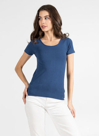 A woman wearing a short sleeve scoop neck top in blue with jeans. 