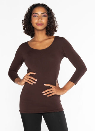 A woman wearing a brown 3/4 sleeve scoop neck top made of bamboo, cotton, nylon, and spandex.