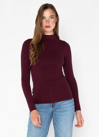 Woman wearing a burgundy mock neck top made of bamboo