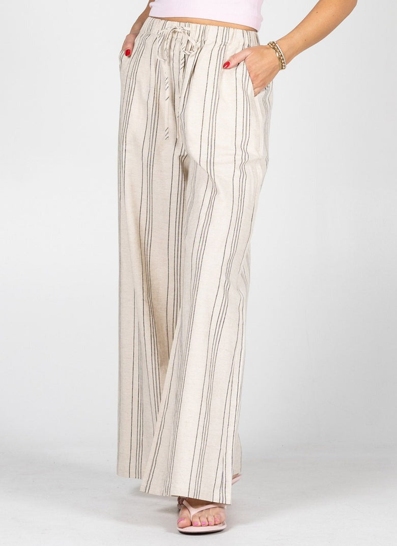 Beige striped pants worn by a person on a white background