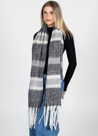 Woman wearing a striped scarf with fringe on a white background