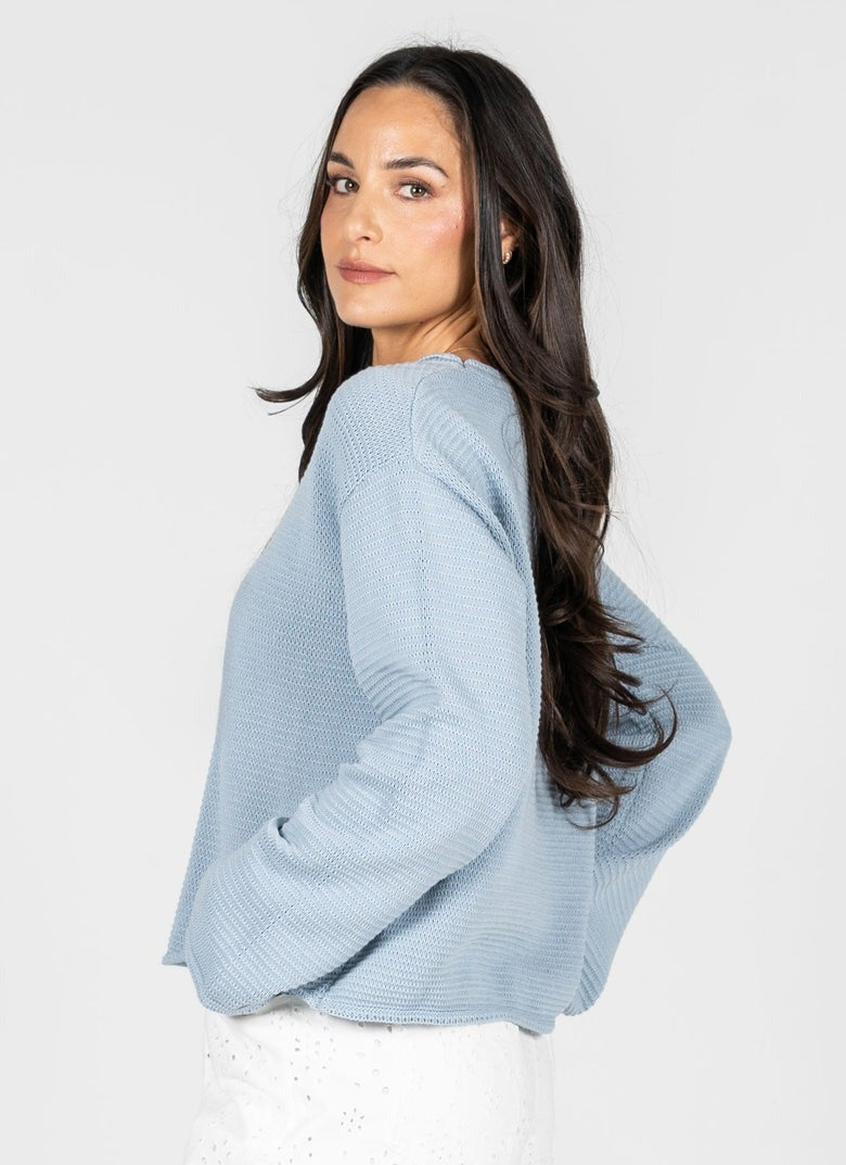 Woman wearing a light blue sweater against a white background