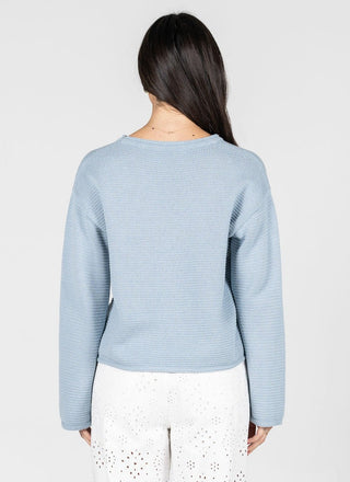 Light blue sweater worn by a person on a white background