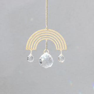 Decorative rainbow hanging ornament with clear crystals on a gray background