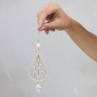 a person holding a tear drop suncatcher