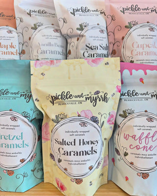 Assorted bags of caramels with visible branding on a wooden surface