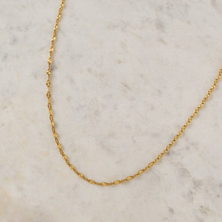 Gold chain necklace on a marble background