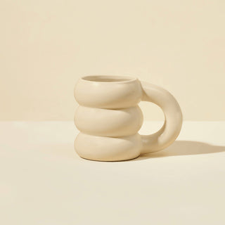 Beige ceramic mug with a unique design on a beige background