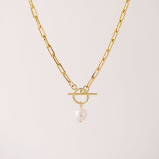 a gold chain link necklace with a pearl drop charm