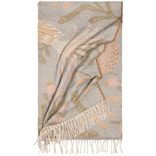 Decorative throw blanket with floral pattern and fringe on a white background
