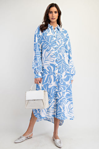 Woman wearing a blue and white leaf-patterned dress on a white background