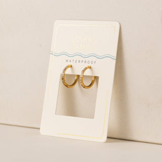 A pair of gold-colored hoop earrings with cubic zirconia stones set in a circle.