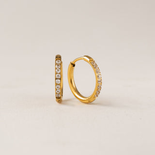 A pair of gold-colored hoop earrings with cubic zirconia stones set in a circle.