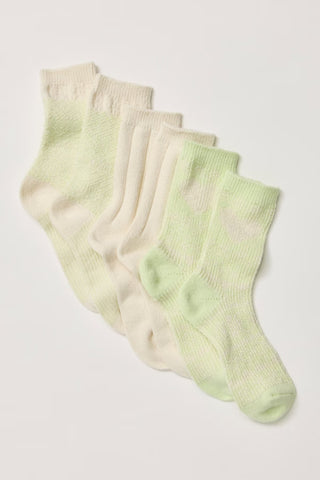 A set of five ribbed knit socks in a soft gradient from cream to pale mint green, arranged diagonally on a light off-white background.