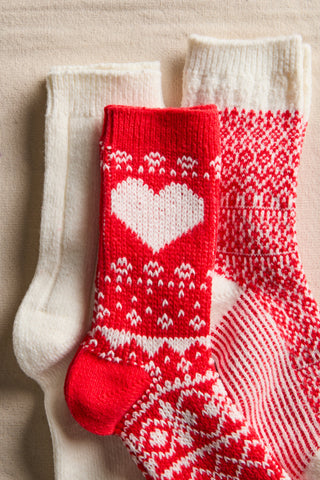 Red and white patterned socks with a heart design on a beige background