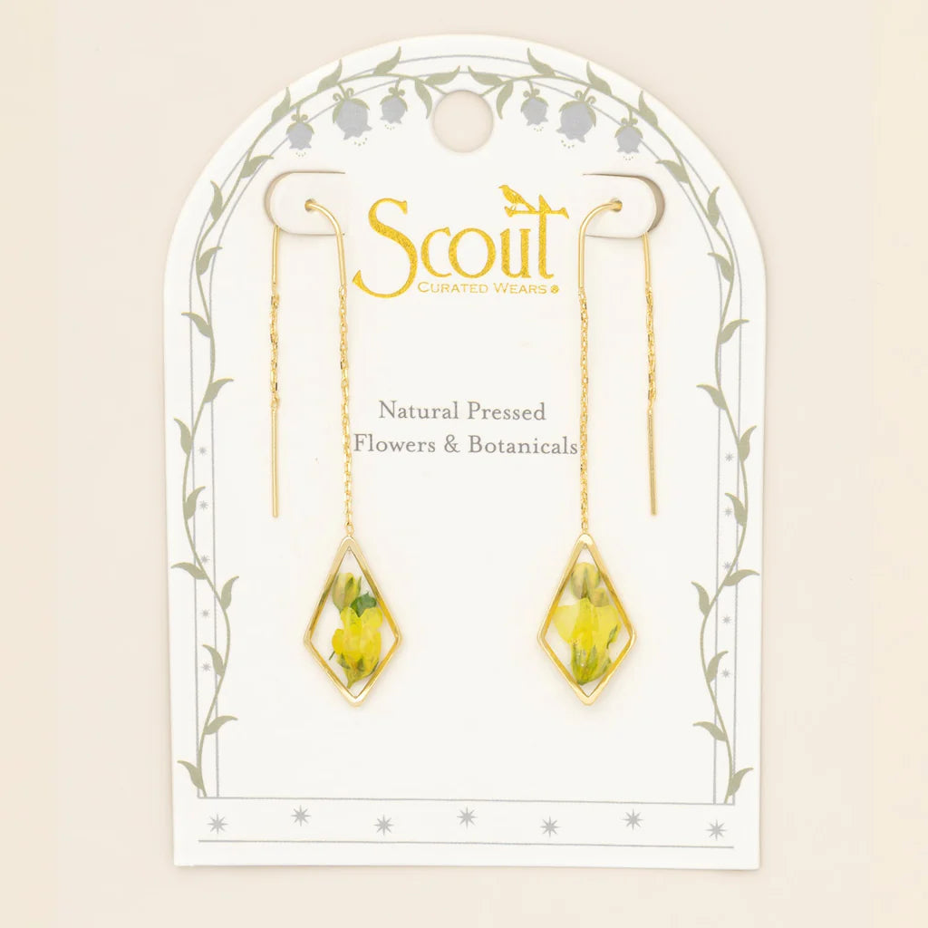 Jewelry card with earrings featuring natural pressed flowers and botanicals, branded 'Scout'.