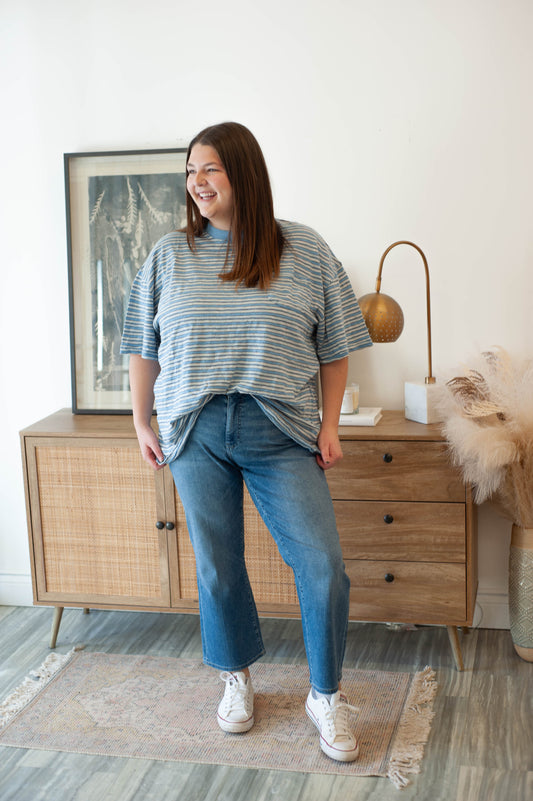 Woman standing in a room with wooden furniture and decor