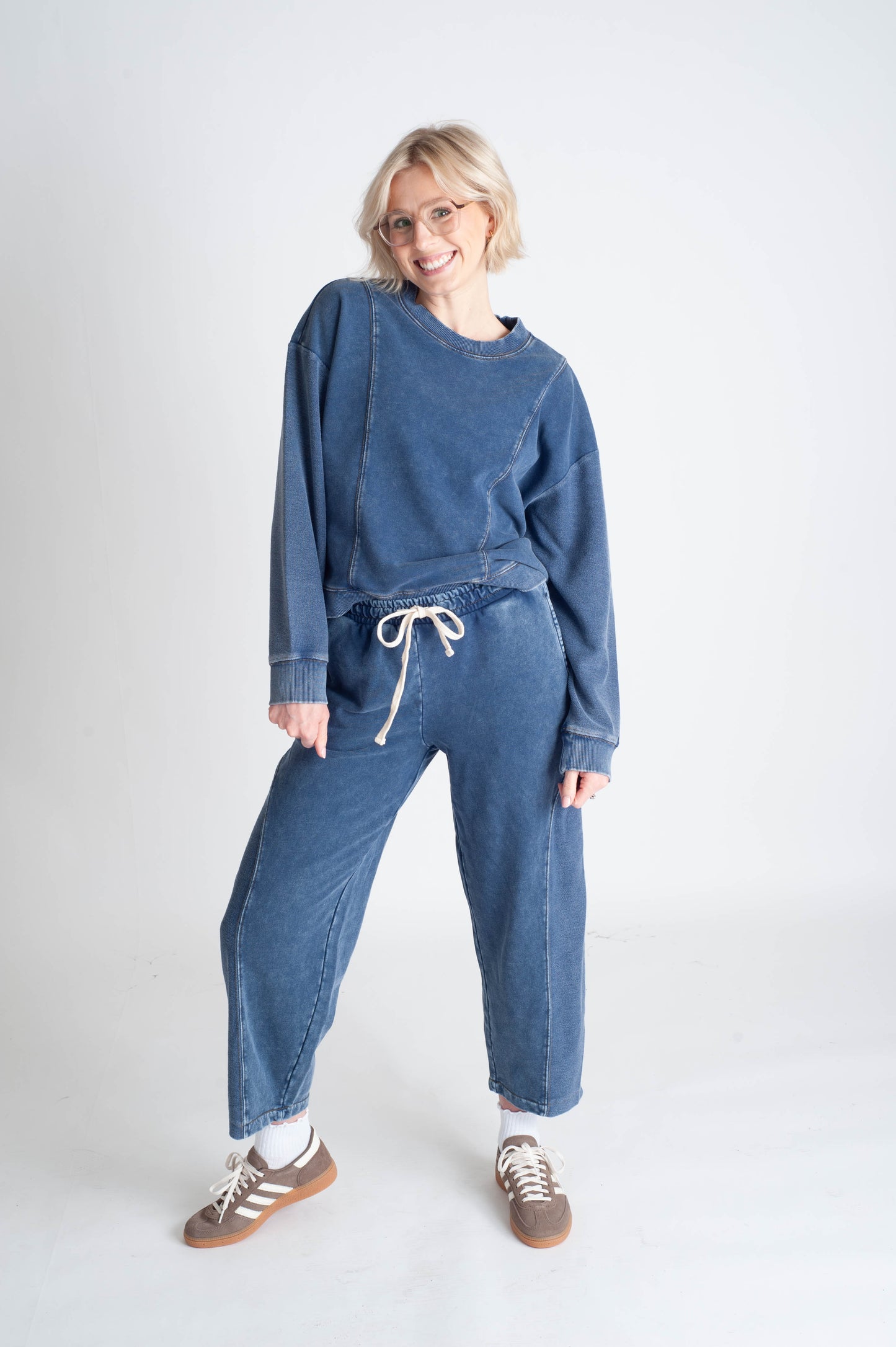 Person wearing a blue outfit with a matching sweater and pants on a white background