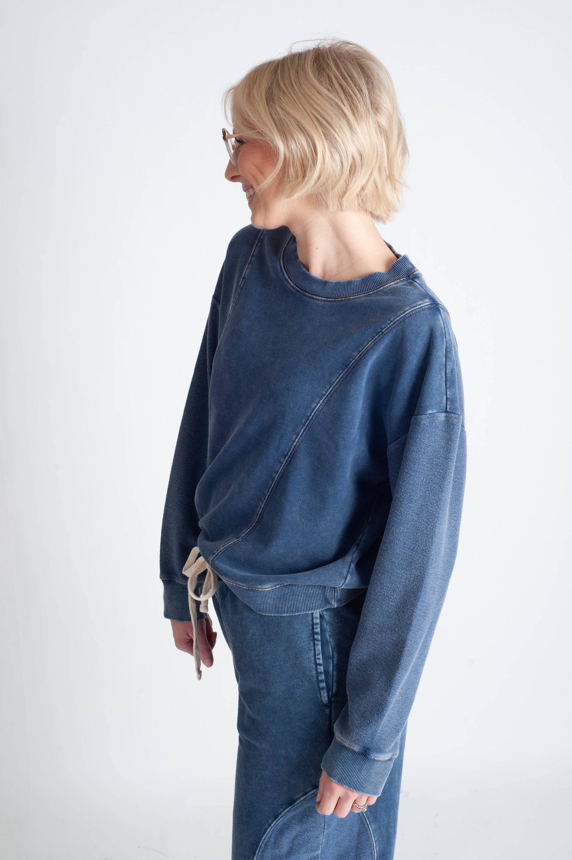 Person wearing a blue denim outfit on a white background