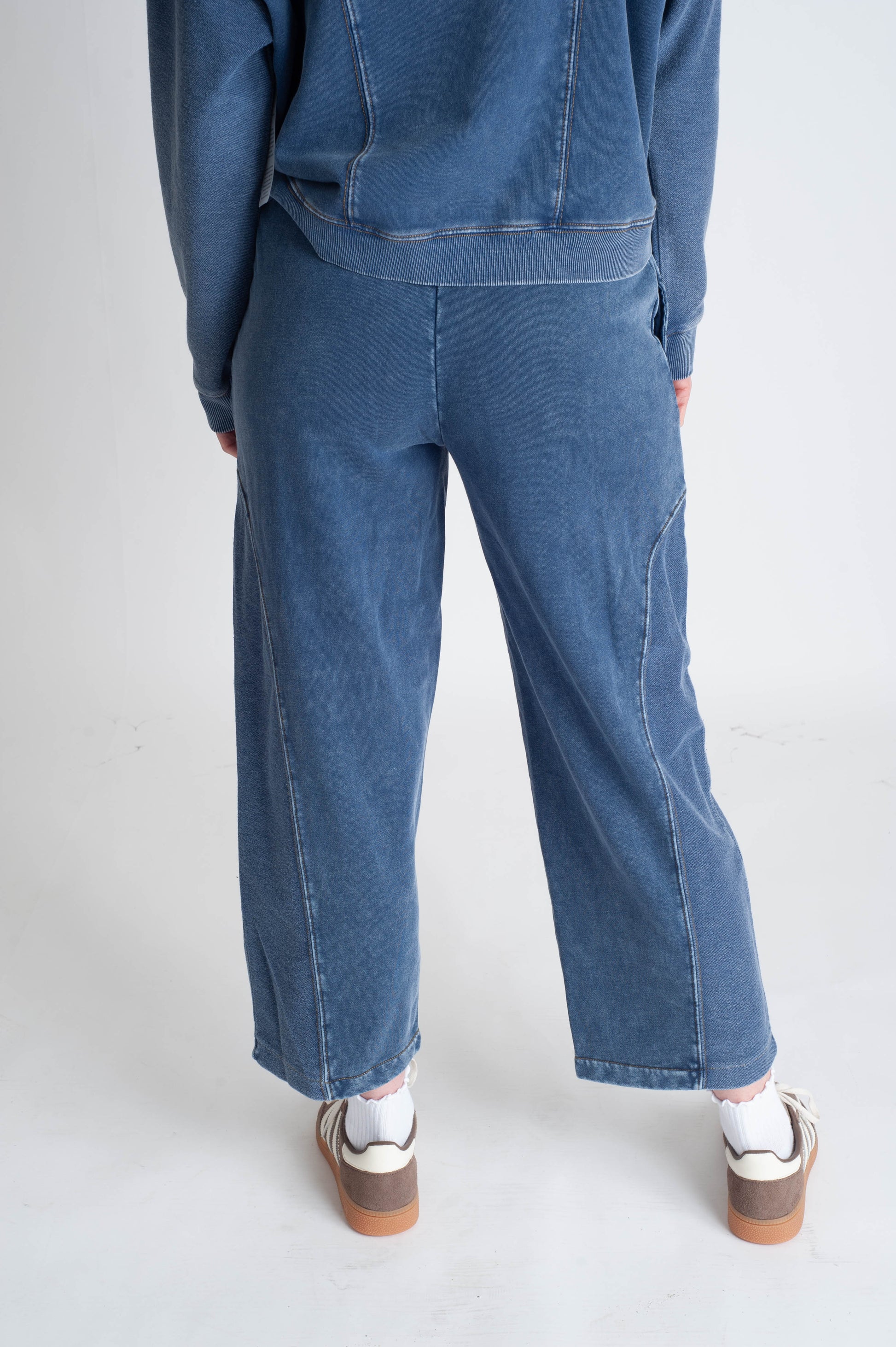 Person wearing blue jeans and a matching jacket on a white background