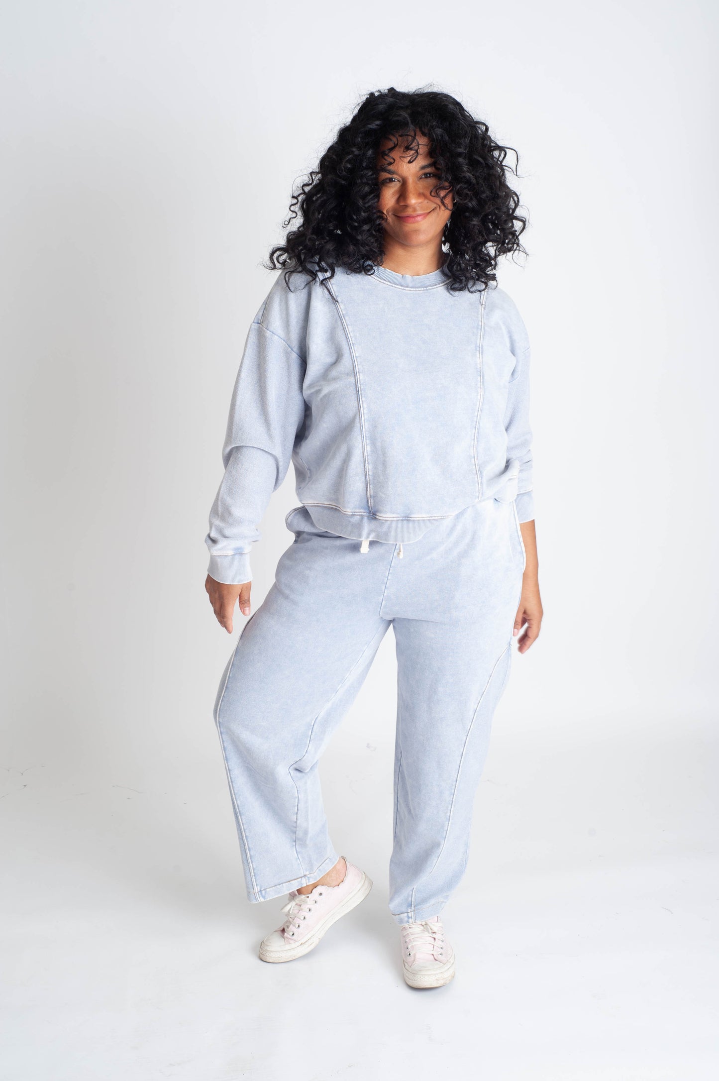 Person wearing a light blue outfit on a white background