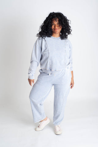 Person wearing a light blue outfit on a white background