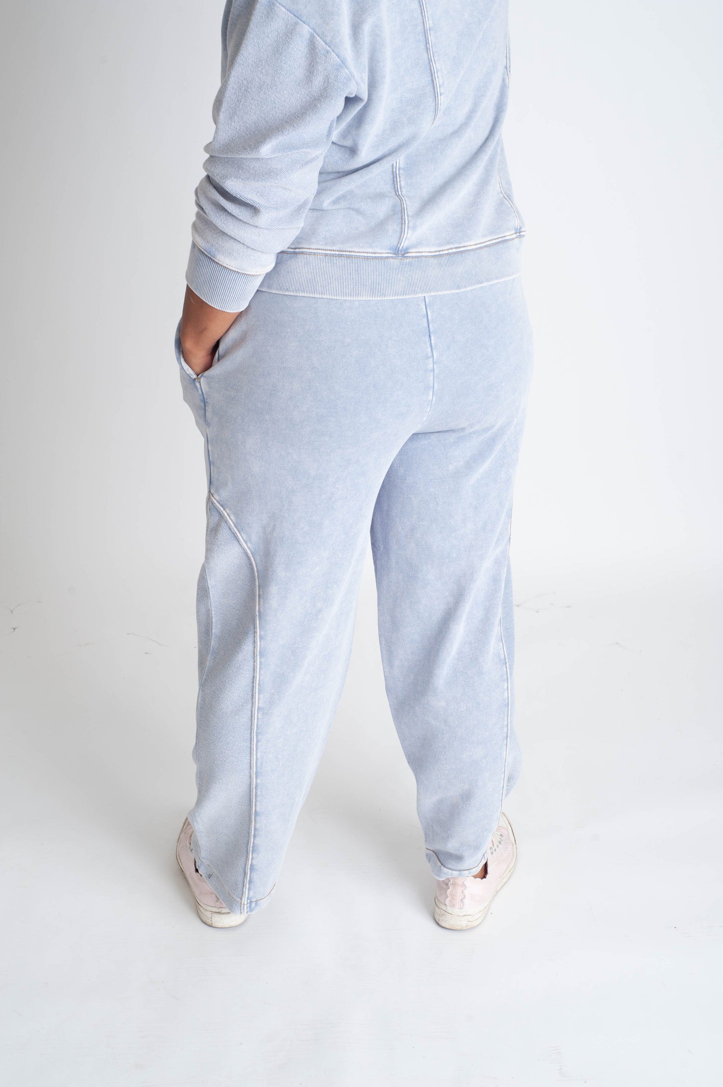 Light blue sweatshirt and pants worn by a person on a white background
