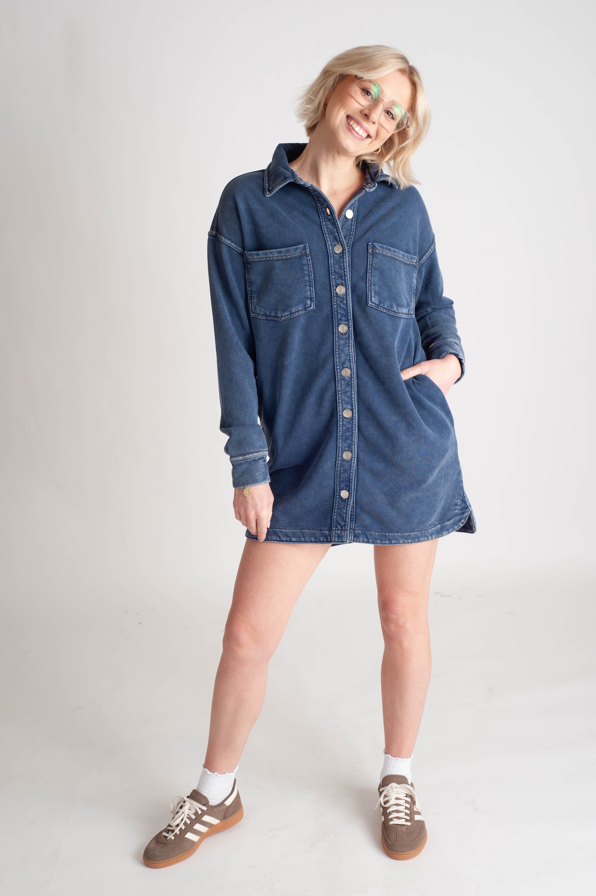 Person wearing a denim dress on a plain background