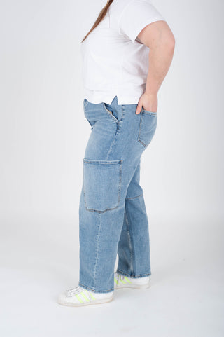 Person wearing light blue jeans and a white shirt on a white background
