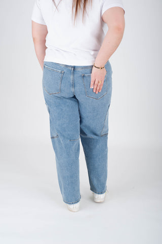 Person wearing light blue jeans and a white shirt on a white background