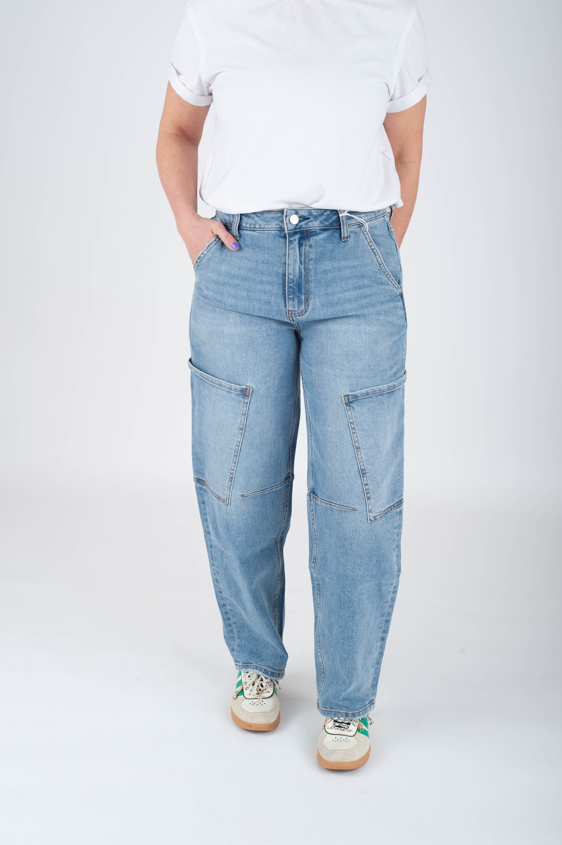 Person wearing light blue jeans and a white shirt on a white background