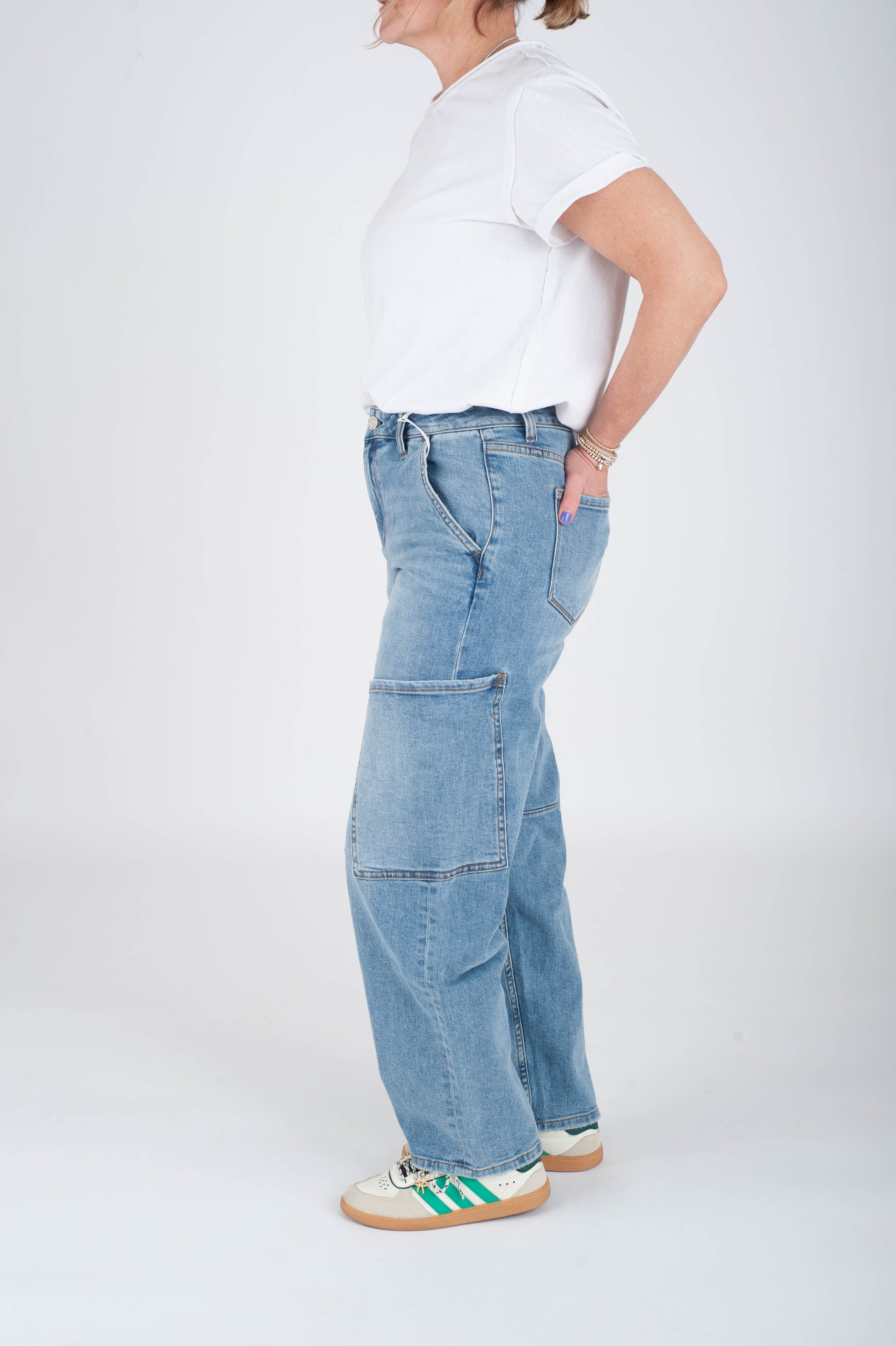 Person wearing light blue jeans and a white shirt on a white background