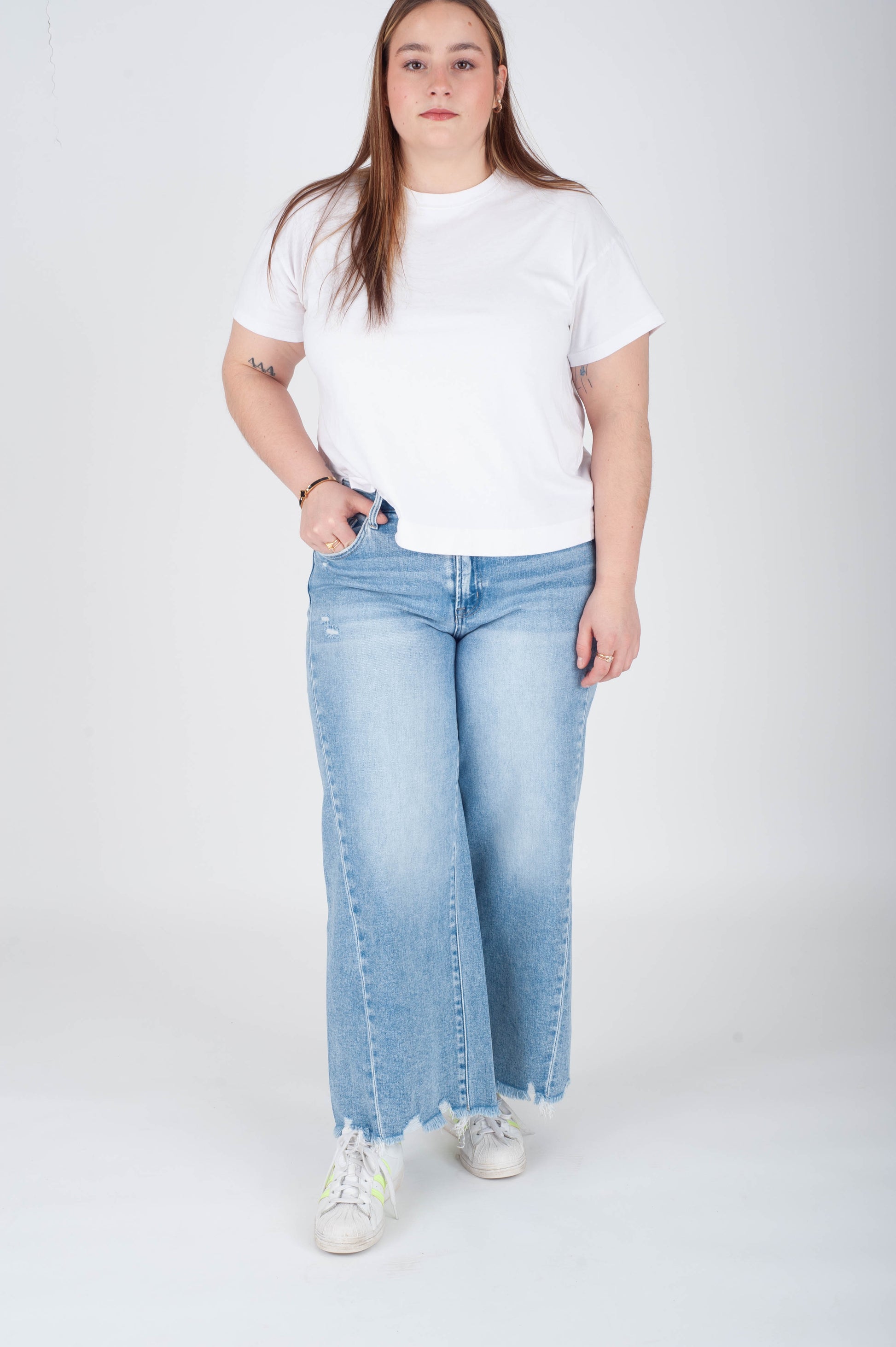 Person wearing a white t-shirt and light blue jeans on a white background