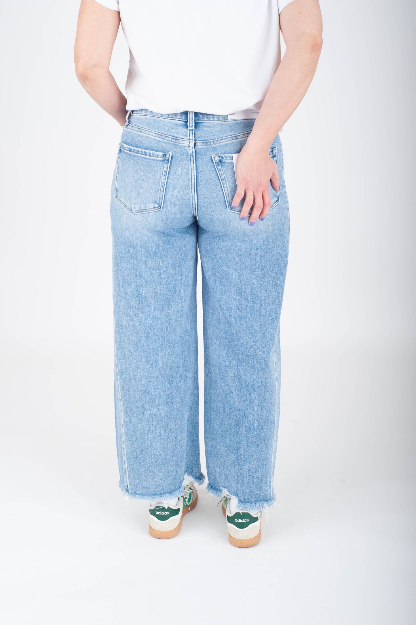 Person wearing light blue jeans on a white background