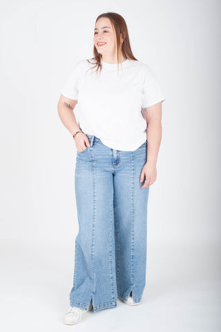 Person wearing a white t-shirt and light blue jeans on a white background