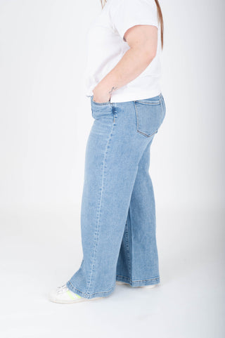 Light blue jeans worn by a person on a white background