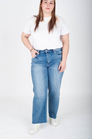Person wearing a white t-shirt and blue jeans on a white background